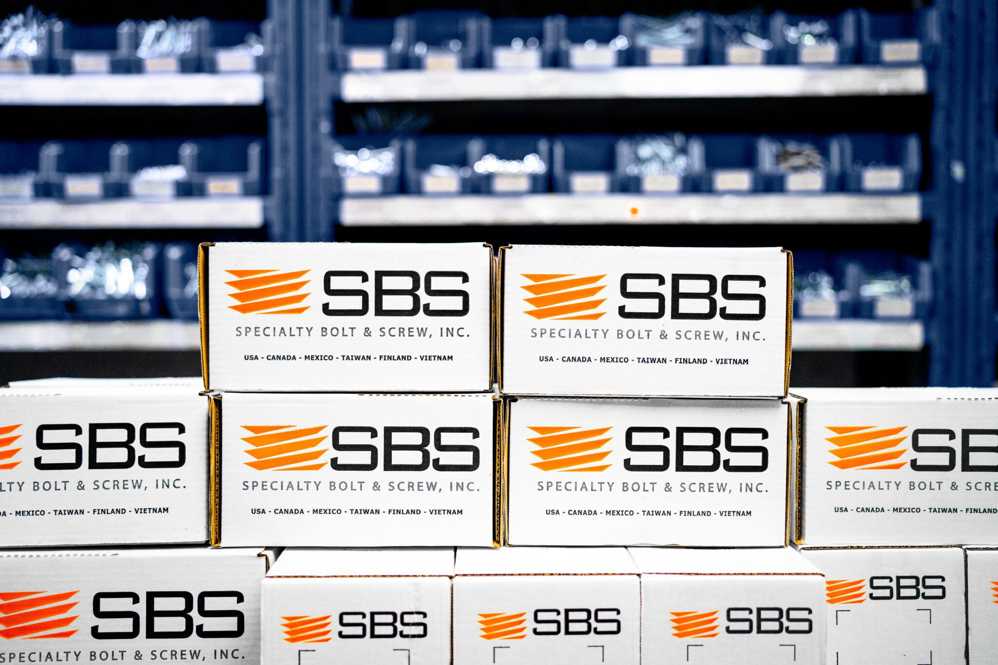 Boxes of fasteners from SBS in front of shelving.