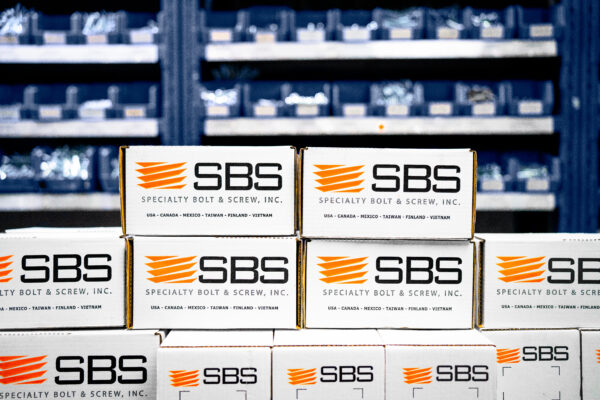 Boxes of fasteners from SBS in front of inventory solutions shelving.